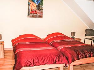 Greiveldange吉雷维丹吉公寓的客房内的一张红色棉被床