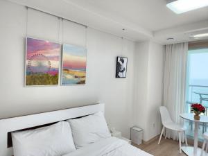束草市Sokcho Summitbay 1209 "Ocean View"的白色卧室配有床和桌子