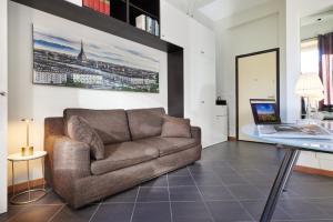 都灵Loft Santa Giulia的带沙发和玻璃桌的客厅