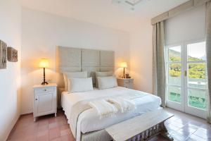 马拉泰亚桑塔维尼尔酒店的卧室设有一张白色大床和一扇窗户。