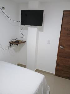 卡塔赫纳HOTEL DI MAR的一间设有床铺和墙上电视的房间