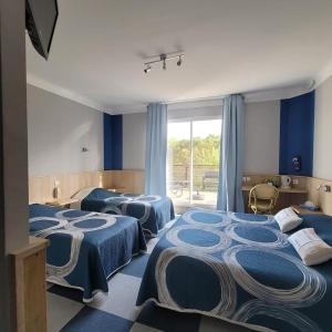圣保罗恩波恩Hotel L'Ecureuil的蓝色墙壁的客房内的四张床