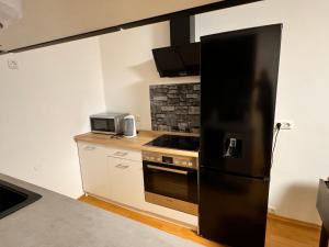 奥格斯堡Gemütliches 1 Zimmer Apartment的厨房配有黑色冰箱和炉灶。