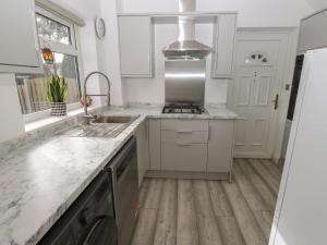 Cosmic Pearl的白色的厨房设有水槽和炉灶。
