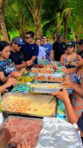 Te-Fare-AriiHaranai Camping & Tours的一群人坐在桌子旁吃着食物