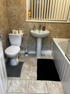 诺丁汉Nice house near cricket ground的浴室配有卫生间、盥洗盆和浴缸。