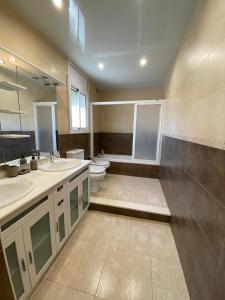 卡拉费尔CAN TRULLEN CHALET CALAFELL的大型浴室设有两个盥洗盆和卫生间。