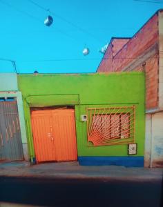拉巴斯Casa familiar orange corner的绿色橙色的建筑,有两个橙色的门