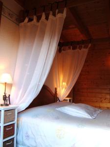 热拉梅爱皮纳特住宿加早餐旅馆的一间卧室配有白色窗帘的床