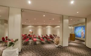 圣卡洛斯-德巴里洛切克里斯托酒店的一间会议室,配有红色椅子和大屏幕