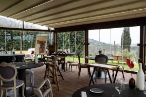 福斯迪诺沃Locanda De Banchieri的餐厅设有桌椅和大窗户。