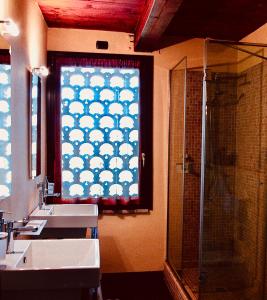博洛尼亚Podere Boschetto R&B的一间带两个盥洗盆的浴室和一间带淋浴的窗户。