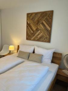 里姆斯廷格Amselnest - b42499的一张带两个白色枕头的床和一张墙上的照片