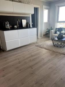 奥斯陆Koselig leilighet på Nordstrand/Lambertseter, Oslo的客厅设有白色橱柜和木地板。