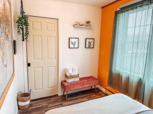 圣马修园Auberge Mandala的一间卧室拥有橙色的墙壁、一扇门和红色的长凳