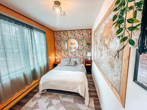 圣马修园Auberge Mandala的卧室配有一张床,墙上有地图