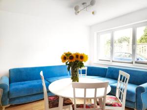 哈日科维APARTAMENTY Charzykowy的客厅配有蓝色的沙发和带鲜花的桌子