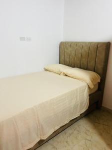 麦德林El Noral的一张带白色床单和枕头的床