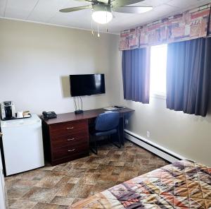 里穆斯基Motel Au Soleil couchant的客房设有一张书桌、一台电脑和一张床