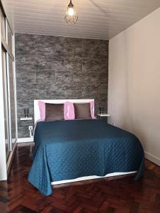 Madalena do MarMaresia's House的一间卧室配有一张带蓝色毯子和粉红色枕头的床。