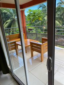 KoungouMaison Villa Dagoni的客房设有带桌子和长凳的阳台。