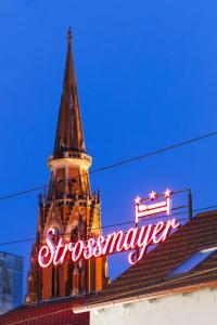 奥西耶克Pansion Strossmayer的一座建筑顶部带有标志的钟楼