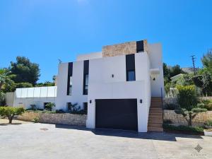 贝尼萨Villa moderna de lujo de nueva construcción a 1km de Playa Fustera - Ref A014 AVANOA PREMIUM RENTALS的白色的房子,设有车库
