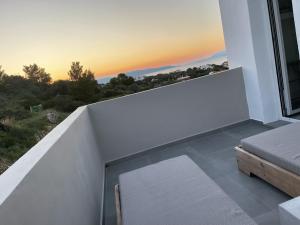斯卡拉villa of the god的一间卧室设有可欣赏日落美景的阳台
