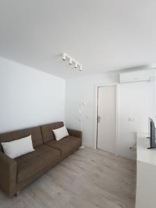 布拉内斯Aiguaneu S'Auguer的客厅设有棕色沙发和白色墙壁。