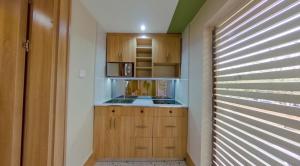 阿布贾C. Apartments Annex的一间带木制橱柜和微波炉的小厨房