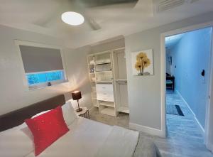 迈阿密Little Gables Studio-Your Miami Escape-10min Airport的卧室配有白色的床和红色枕头