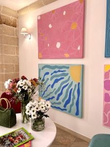 阿韦特拉纳La Vetrana Rooms的墙上装饰有鲜花和绘画的房间