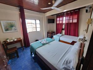 普卡尔帕Hotel Virrey Pucallpa EIRL的酒店客房设有两张床和一张桌子。