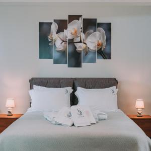 雅典Plaka Sofi Suite的一间卧室配有一张带3幅白色兰花画的床