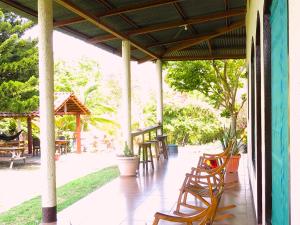 莫约加尔帕Casa Reyna的门廊配有木椅、桌子和树木
