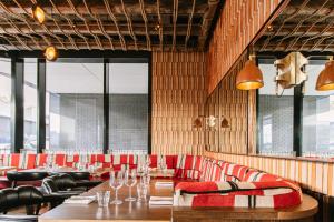 都柏林Sonder at Britain Quay的餐厅设有长桌和红色椅子