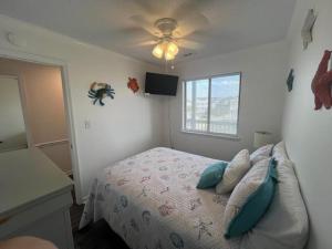 默特尔比奇Sea Shadow 205 Condo的一间卧室配有一张床和吊扇