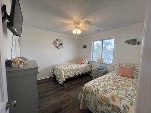 默特尔比奇Sea Shadow 205 Condo的一间卧室配有两张床和吊扇