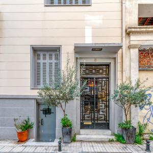雅典Plaka Sofi Suite的通往前面树木的建筑的门