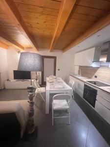 奥斯塔Grazioso appartamento的厨房配有白色的桌子和桌椅