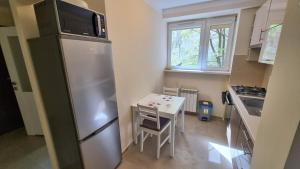 克拉科夫Apartment Katamaran的厨房配有不锈钢冰箱和桌子