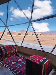 瓦迪拉姆desert wadi rum camp的客房享有沙漠美景,设有窗户。