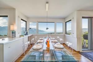 Le Châtelard-MontreuxPanoramic 3BD Dream Family Villa in Montreux by GuestLee的一间带桌子和一些窗户的用餐室