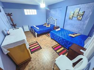 乌尤尼Hotel Aguilar的蓝色的客房配有床和沙发