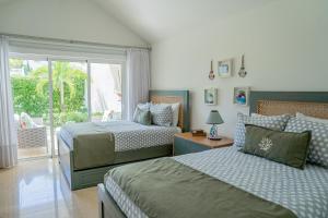 圣斐利-银港Xeliter Green One Playa Dorada的一间卧室设有两张床和滑动玻璃门