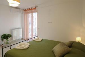 陶尔米纳La Perla的一间卧室配有绿床和2条毛巾
