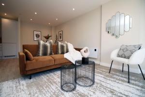 卡迪夫Casablanca 4 - Cardiff Bay - 2 Bed Apartment的客厅配有棕色沙发和白色椅子