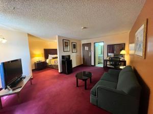 德明Motel 6 Deming, NM的带沙发、电视和床的客厅