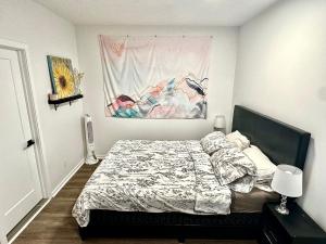 蒙特利尔Beautiful Luxury Shared Home in Montreal的卧室配有一张床,墙上挂有绘画作品