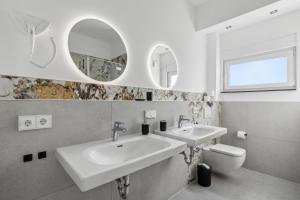 迪岑巴赫SUITE4ME - Moderne Apartments I Küche I Balkon I Waschmaschine的一间带两个盥洗盆、卫生间和镜子的浴室